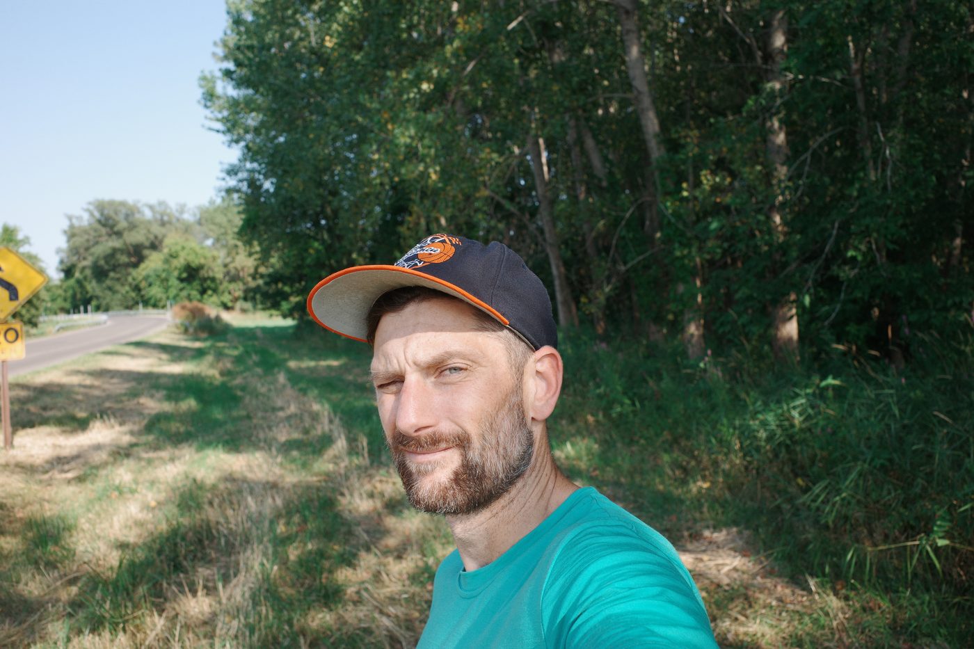 Tim VanBenschoten in a ballcap on a tree-lined country road